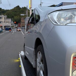 静岡市葵区の路上でタイヤバーストを起こしたシルバーのミニバンをレッカーの積載車に積み込んでいる様子